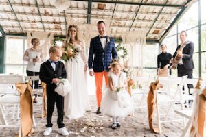 Brautpaar und Blumenmädchen im Hiintergrund die Band