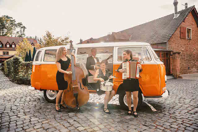 flexible und akustische Musiker beim Hochzeitsempfang neben ihren Bandbus
